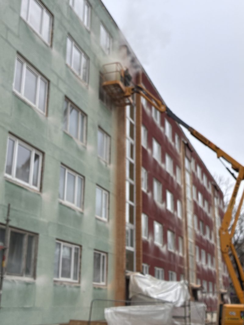 Kortermaja fassaad, kõrval tõstuk ja tolm